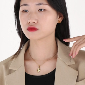Close-up of golden fashion necklace and stud earrings set with cartoon girl motifs