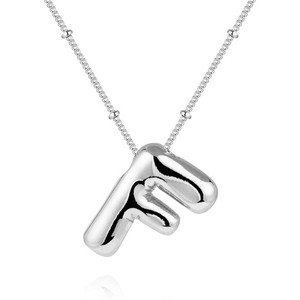 Macro shot of silver bubble letter F pendant with polished reflective metallic finish