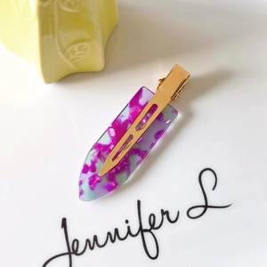 Macro detail of acetate hair clip with purple marble pattern and gold metal duckbill