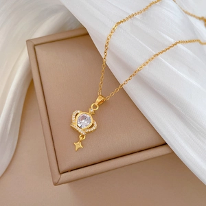 Macro detail of gold crown heart necklace pendant with sparkling crystals and star