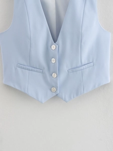 Gros plan détaillé du gilet bleu clair montrant les boutons perlés et la texture en sergé