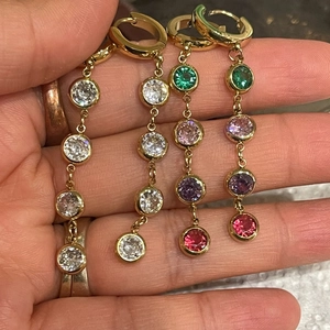 Elegant gold drop earrings with colorful zircons and tassels in a geometric design