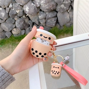 Pink bubble tea silicone AirPods case with strap held against a stone wall background