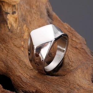 Polished silver square signet ring displayed on rustic dark wood background