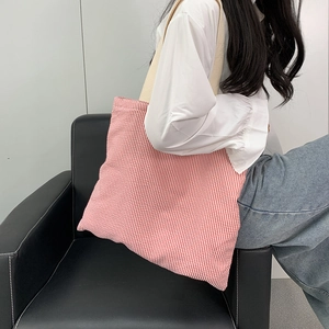 Close-up of red and white striped canvas tote bag with off-white wide shoulder strap