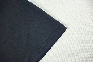 Detailansicht des doppelt genähten Saums an schwarzem Strickstoff mit Textur