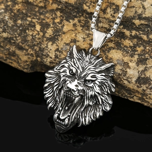 Macro shot of silver stainless steel viking wolf head pendant on box chain necklace