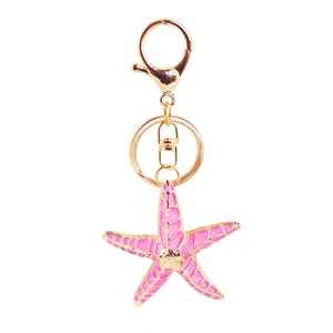 Cute pink starfish keychain with gold hardware on white background for bag charm accessories