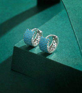 Detailed macro view of 925 sterling silver hoop earrings with turquoise stones inlay