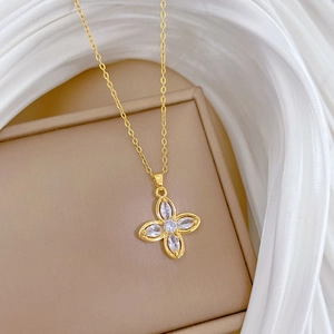 Elegant gold four-leaf clover necklace with sparkling diamonds on beige velvet gift box