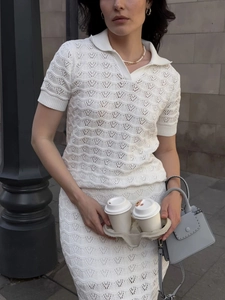 Detail of elegant ivory crochet knit polo set with wave patterns on a slim skirt