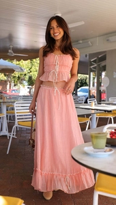 Detail of pink two-piece set featuring drawstring crop top and ruffled long skirt texture