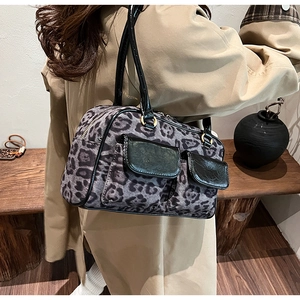 Detail of leopard print shoulder bag featuring suede texture and black patent leather straps
