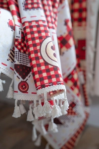 Detail of red and white plaid Christmas kitchen curtain with soft fringe tassels
