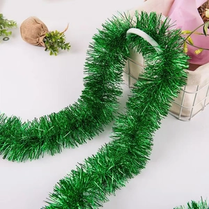 Detail of 2-meter green tinsel garland draped on a white mesh basket for festive decoration