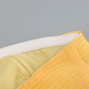 Détail de la robe plissée jaune avec bande de silicone antidérapante et taille élastique
