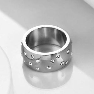 Macro detail of silver stainless steel ring with scattered crystal inlay and polished finish