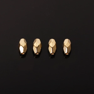 Golden faceted CCB rhombus spacer beads for DIY jewelry making on a black background