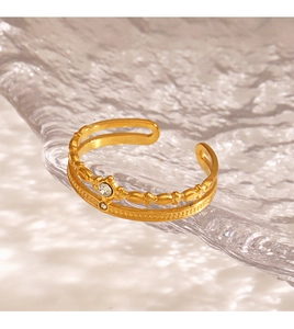 Macro shot of 18K gold plated double-layer open ring with crystal on water ripple glass