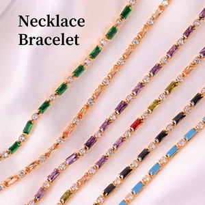 Elegant gold necklace and bracelet set with colorful emerald-cut stones on pink silk