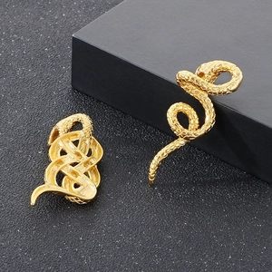 Gros plan détaillé de pendentifs serpent dorés avec textures d'écailles sur fond noir