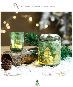 Frosted green glass Christmas lanterns with reindeer patterns on rustic wood base