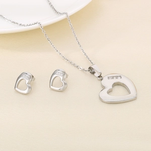 Detail of silver heart jewelry set featuring hollow pendants with inlaid crystals