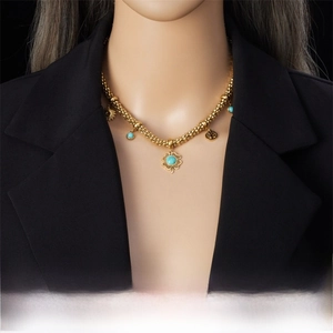 Detail of clover and tree of life turquoise pendant on gold stainless steel chain
