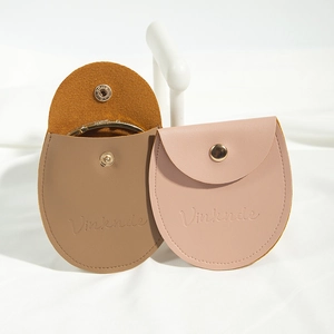 Detail view of pink and brown semi-circle PU leather jewelry pouches with snap closures