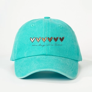 Détail de la broderie cœur et du texte sur la casquette en coton vert menthe délavé
