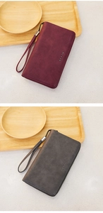 Detail of RFID oil wax leather wallets in burgundy and grey with wristlets and gold logo
