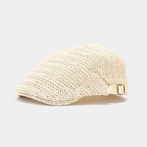 Close-up of woven straw texture and metal adjustment buckle on beige beret hat