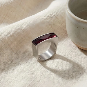 Macro detail of rectangle red gemstone set in a brushed silver stainless steel band