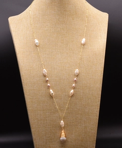 Macro shot of long golden necklace with baroque pearls and a teardrop pearl pendant