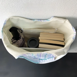 Intérieur spacieux du sac en toile rayé avec poche ouverte et compartiment zippé