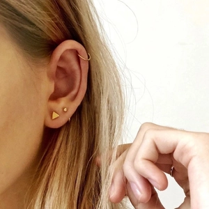 Primer plano de modelo con conjunto de pendientes de botón y aro en plata 925 dorada