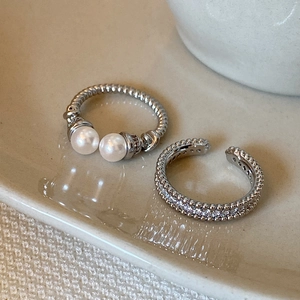 Elegant silver-tone open ring featuring white pearls and zircon accents on ceramic tray