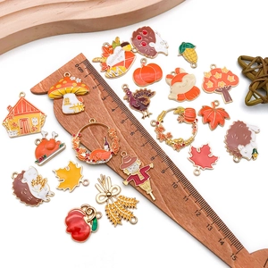 Macro view of assorted Thanksgiving enamel charms displayed next to a scale ruler