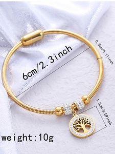 Detail of tree of life charm and crystal rings on gold titanium magnetic bracelet