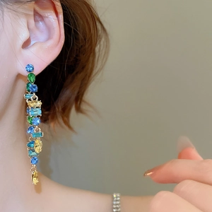 Close-up of colorful rhinestone tassel earrings showing geometric drops and vibrant shine