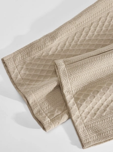 Detail of beige waffle weave fabric texture with clean stitched hem for men's casual set