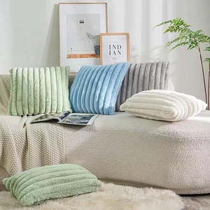 Modern faux rabbit fur striped plush throw pillows in multiple pastel colors on a sofa