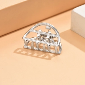 Detailed close-up of a silver hollow geometric crown-shaped metal hair claw clip