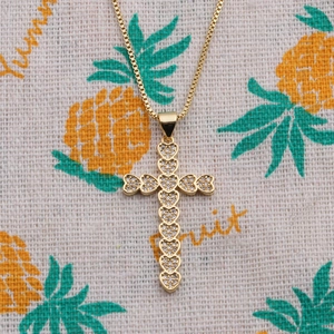 Detail view of heart-shaped gold cross pendant with cubic zirconia and box chain