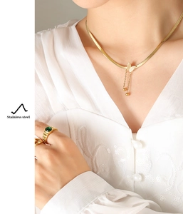 Detailed view of model wearing butterfly pendant necklace and ring in stainless steel