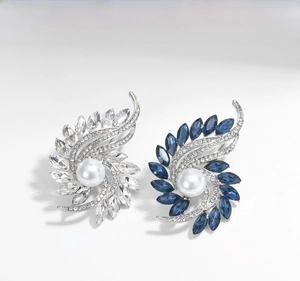 Detail of silver brooches with large pearls and white or blue sparkling rhinestones