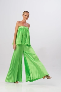 Dettaglio del tessuto plissettato verde lime sul set con top a fascia e pantaloni larghi