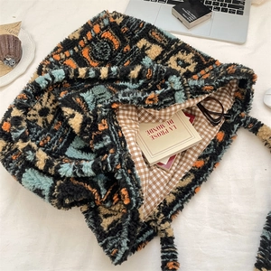 Close-up of plush tote bag showing geometric patterns and brown checkered cotton lining