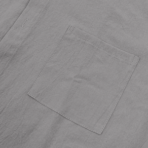 Detail of gray linen shirt showing fabric texture and reinforced patch pocket stitching