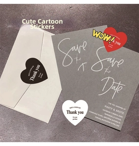 Close-up of heart-shaped Thank You stickers on a grey invitation card for gift sealing